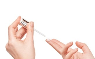 Hände geben einen Tropfen Serum auf einen Finger
