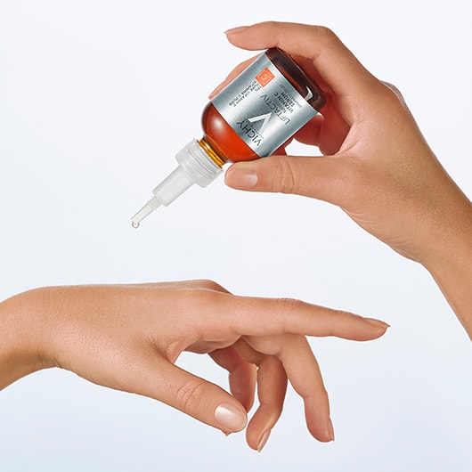 Person tröpfelt ein wenig Vichy LIFTACTIV Serum auf ihren Handrücken