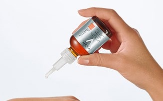 Person tröpfelt ein wenig Vichy LIFTACTIV Serum auf ihren Handrücken