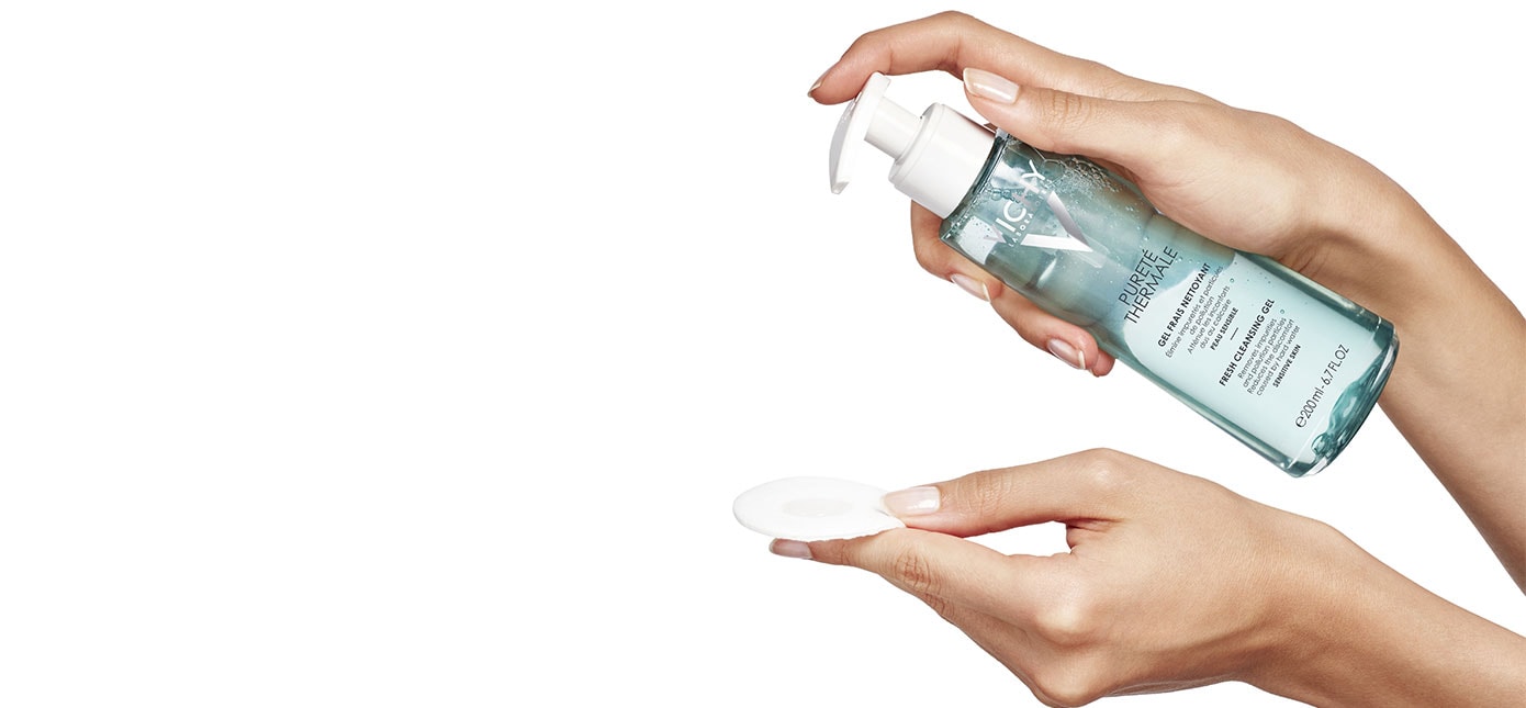 Person macht Reinigungsgel auf ein Wattepad