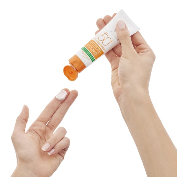 Person drückt einen Klecks Vichy Sonnencreme mit LFS 50 auf einen Finger