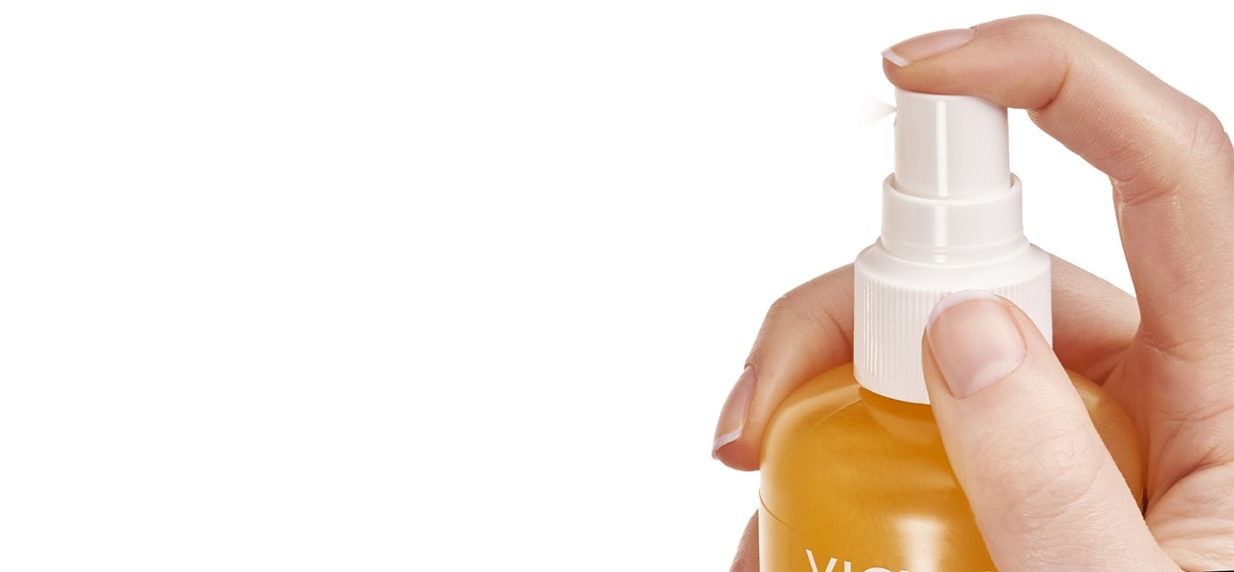 Person drückt auf auf den Pumpkopf eines Sonnensprays