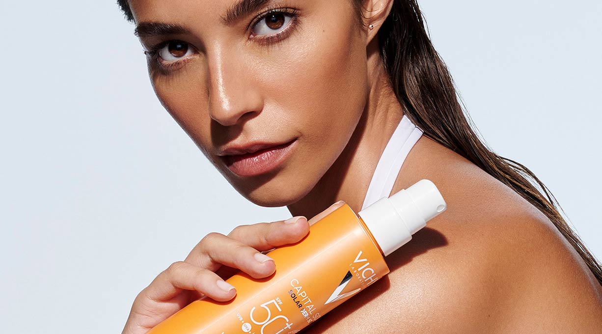 Frau hält ein CAPITAL SOLEIL Cell Protect Sonnenspray mit LSF 50