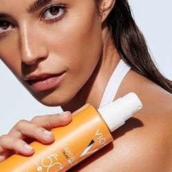 Frau hält ein CAPITAL SOLEIL Cell Protect Sonnenspray mit LSF 50